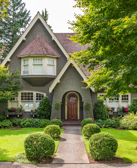 Beautiful suburban house with a green lawn, representing residential property and homeowners insurance.