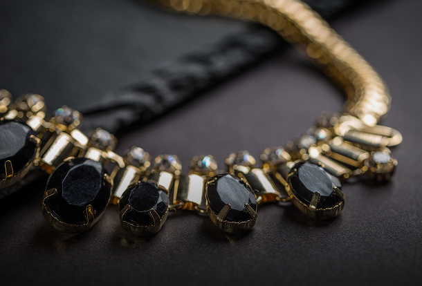 Elegant black and gold necklace displayed on a mannequin, representing jewelry insurance for high-value fine jewelry.