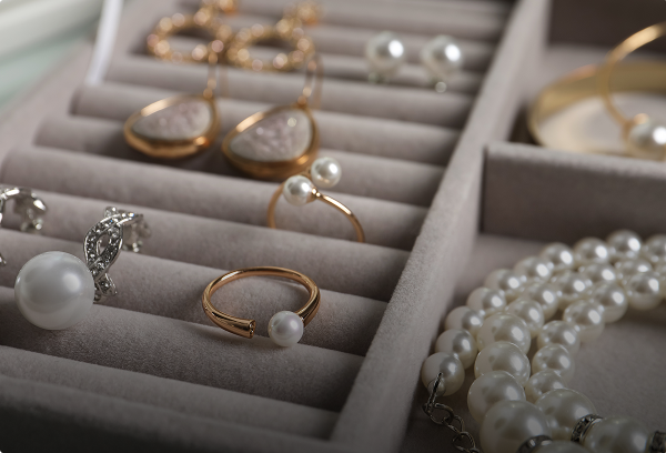 An elegant jewelry storage organizer filled with arranged gold rings, diamond earrings, and delicate necklaces.