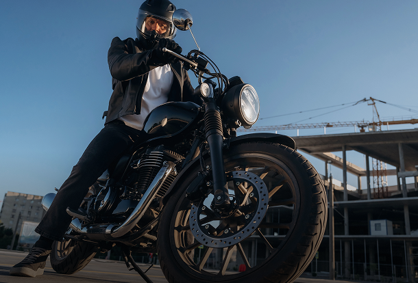 Man riding a modern black motorcycle, representing reliable motorcycle insurance.