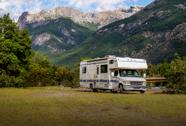 Motorhome parked near scenic mountains, representing comprehensive RV insurance for outdoor travel and camping trips.