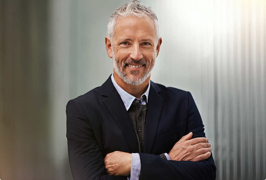 Smiling mature businessman in a professional suit representing commercial insurance services.